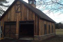 Rustic Barn-Style Garage with Natural Wood Siding and Stone Skirt